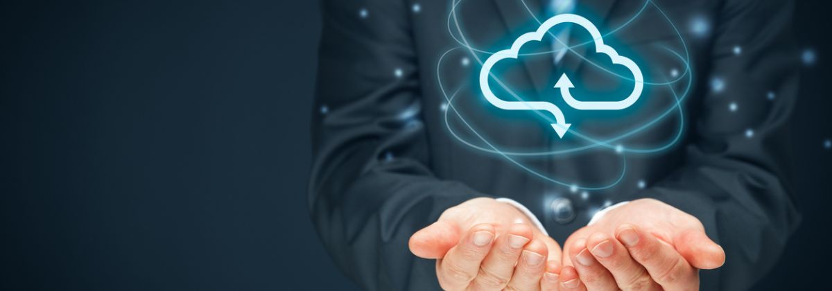 Businessperson holding a glowing cloud computing icon with arrows, symbolizing data exchange and cloud technology.